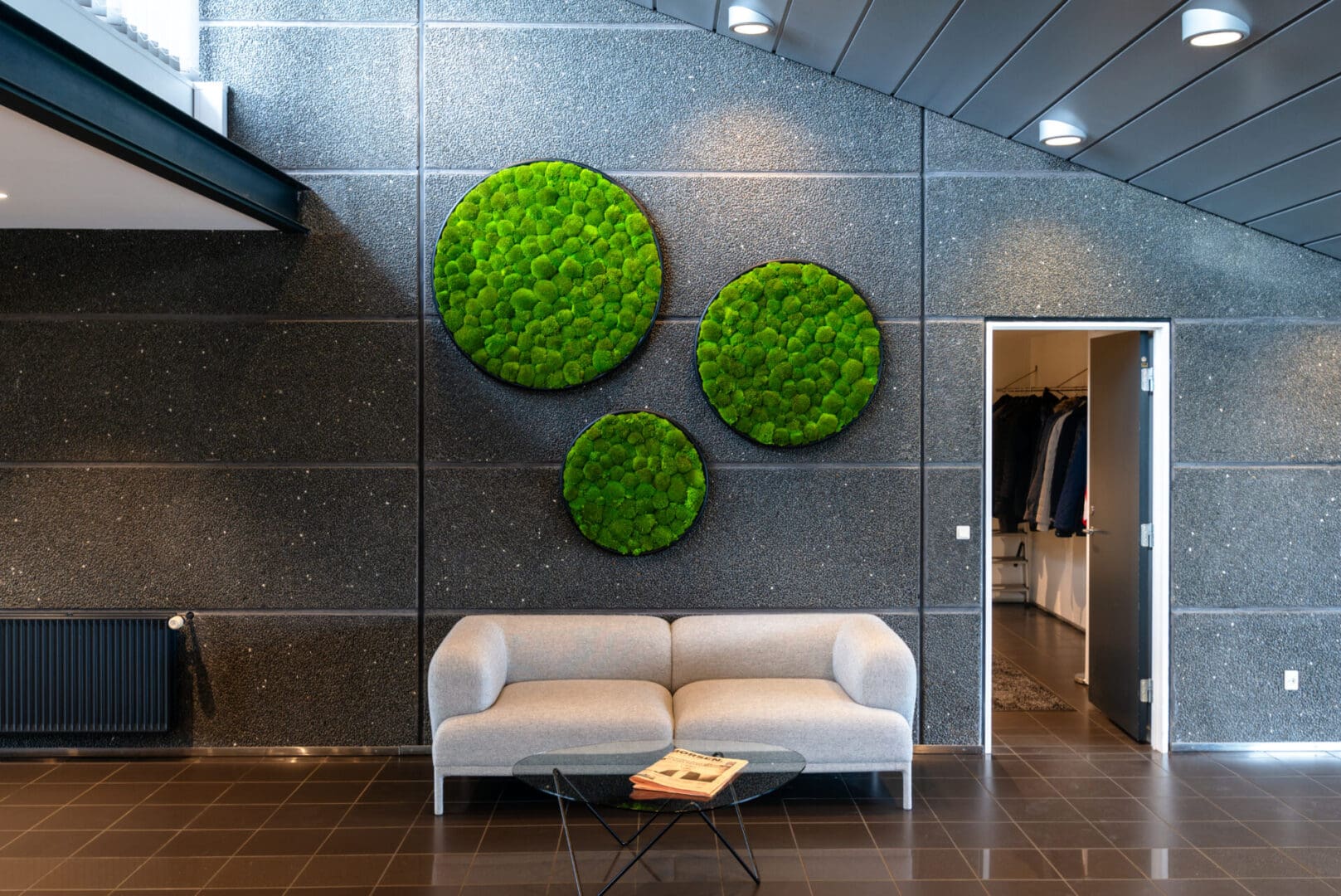 A living wall with three round pieces of green grass.