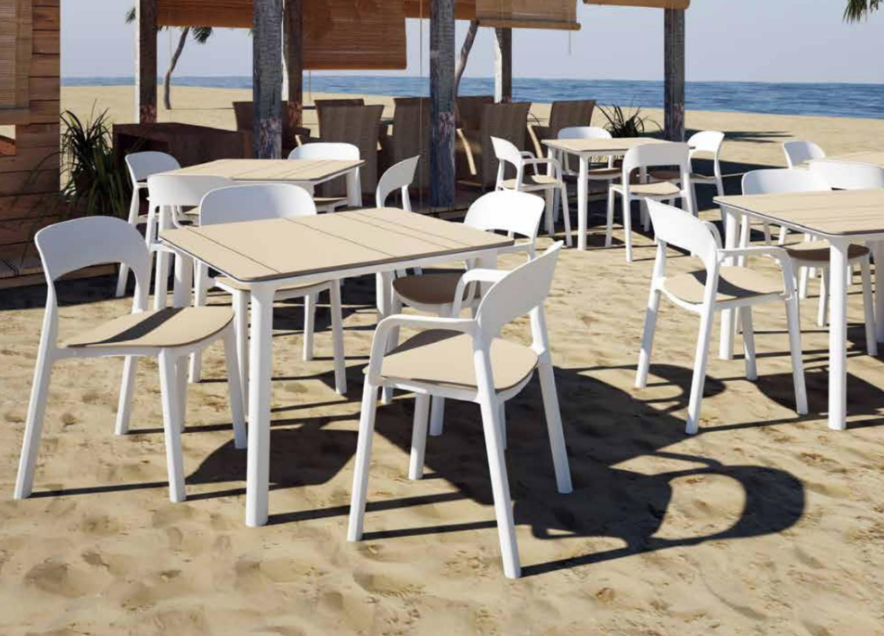 A group of tables and chairs on the beach.